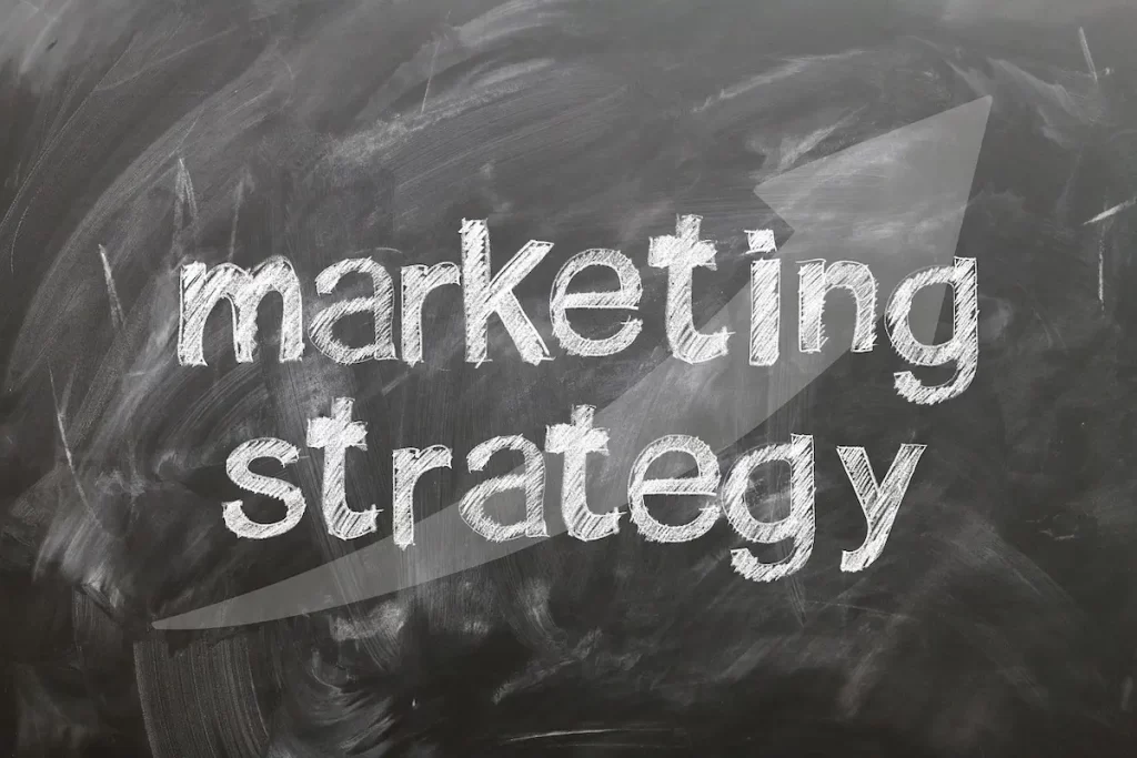 blackboard with the words "Marketing Strategy" written on it - لوحة سوداء مكتوب عليها "استراتيجية التسويق"